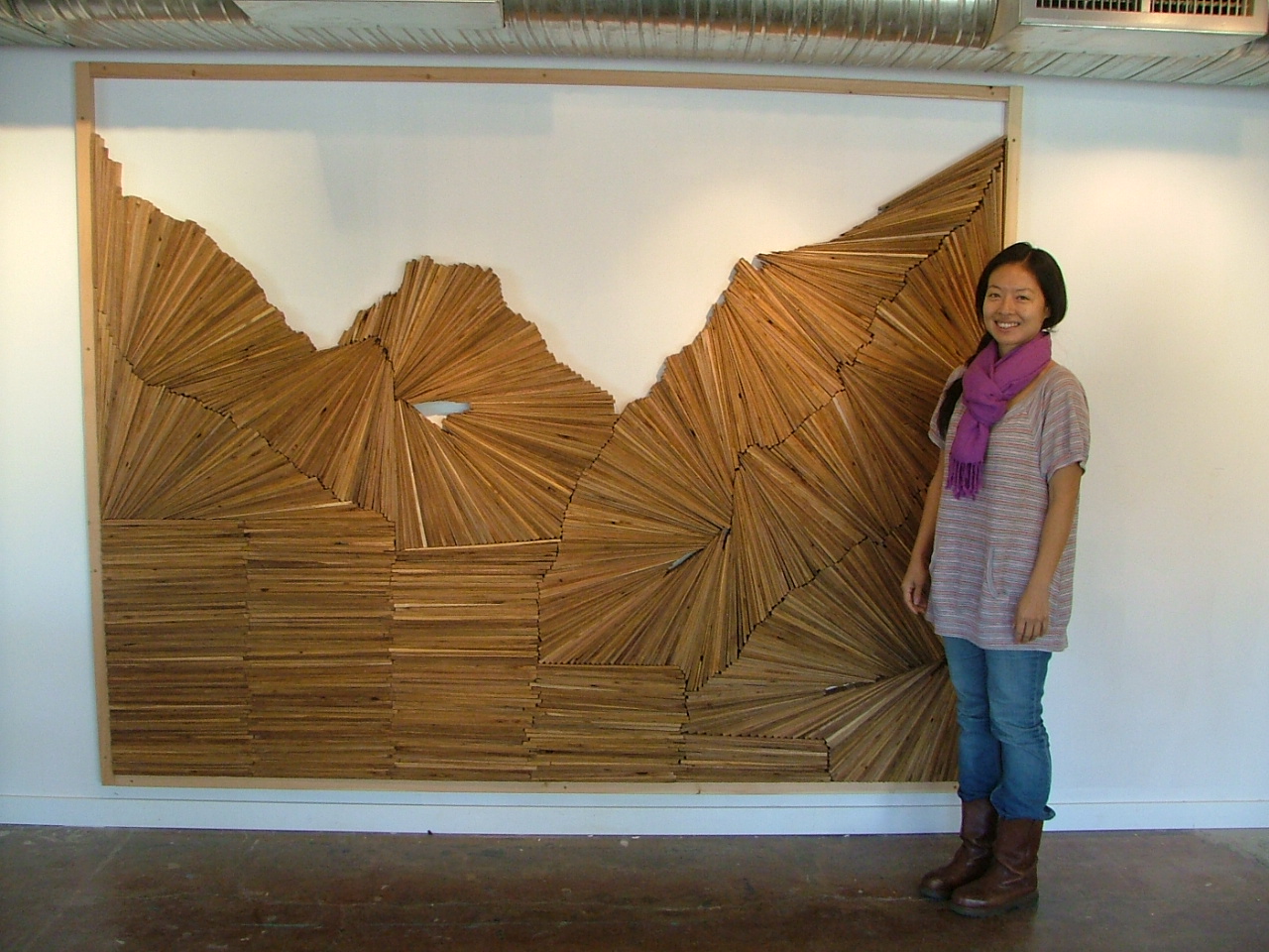 Visiting artist Christine Lee stands next to one of her pieces at the 